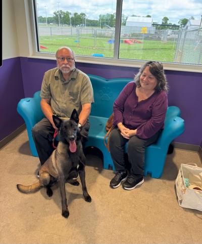 Scout the dog with his two adopters