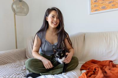 Person sitting on a couch with a cat in her lap