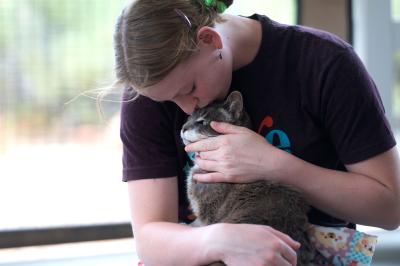 Person hugging a cat in her lap