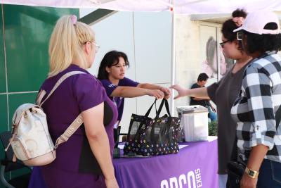 Person at the SPCA of Texas cat help desk handing a carrier containing kittens to a person