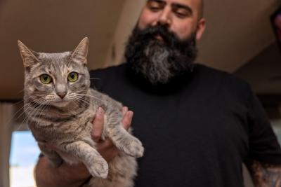 Chris Alton holding Jane the cat with one hand