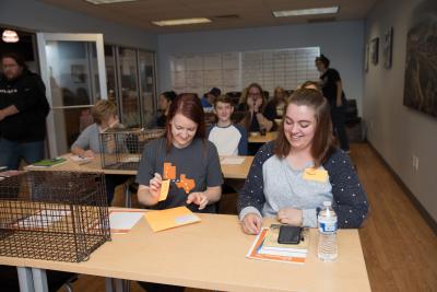 People attending a community cat day with live traps on the tables