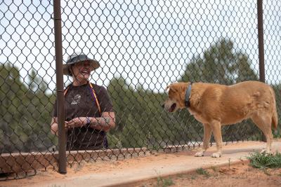 Crysteena outside a fence interacting with Prairie Dawn the dog