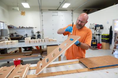 Volunteer Curtis McIff crafting a wooden chair