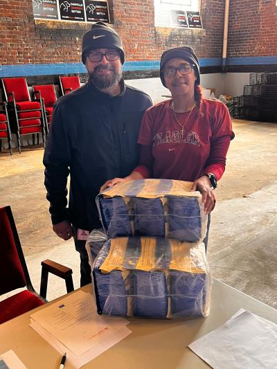 Two people with bags of pet food on a table
