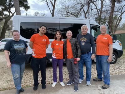 David Temple and a group of people, many wearing orange Best Friends shirts, standing in front of a pet transport van
