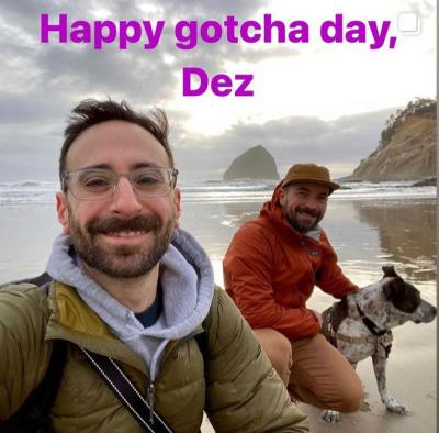 Dez the dog with his adopters with the words, 'Happy gotcha day, Dez'
