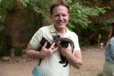 Volunteer Bill Coaker holding three kittens outside at a Discovery Weekend event