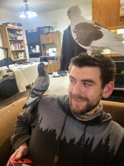 Kyle with Ethel and Skylar the pigeons on his shoulder and head
