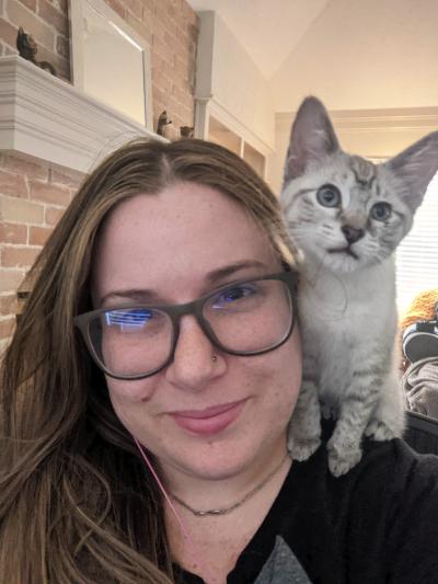 Siamese mix kitten sitting on Jennifer Ronzello's shoulder