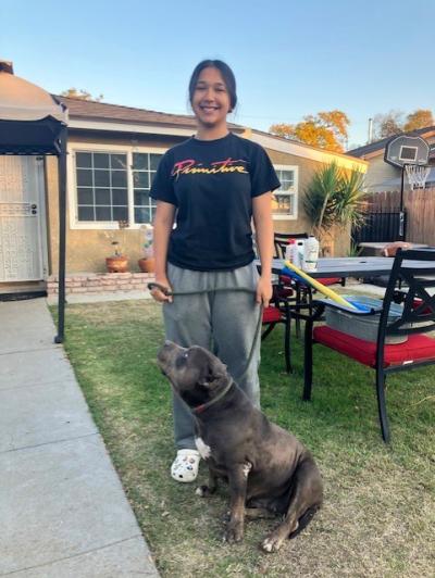 Smiling person with her pit bull terrier after the dog had been returned by an animal control officer
