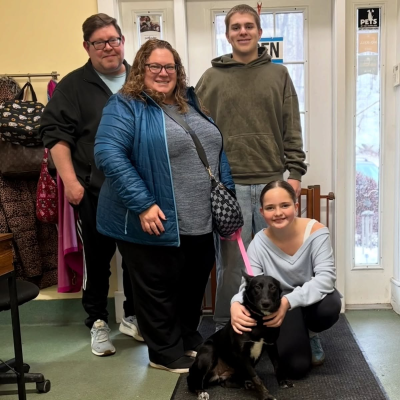 Lillie the dog with her adopters