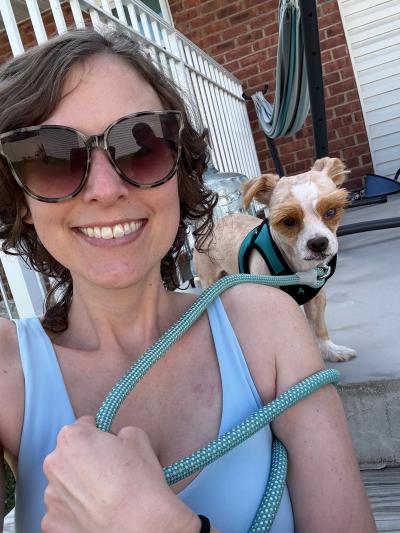 Hawkeye the dog on a leash beside the vet who adopted him