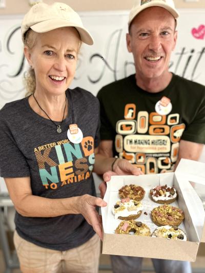 Volunteers Bob and Hope McCullen holding a box of baked treats