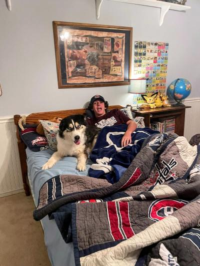 Hank the dog in bed with a person at his new home
