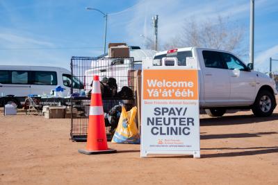 Best Friends spay/neuter clinic welcome sign beside a truck and some wire kennels