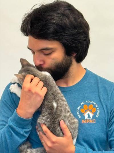 Justin Serna holding and kissing a kitten