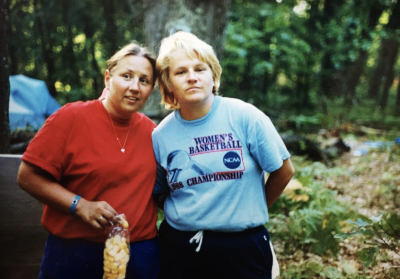 A young Tawny Hammond with another person in the woods
