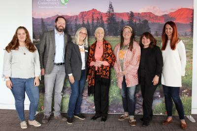 Group of Best Friends employees beside Jane Goodall with a mountain mural behind them