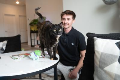 Emmalee the tortoiseshell cat on a table next to Isaac