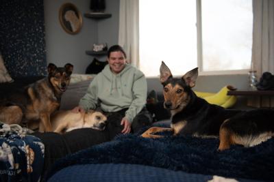 Jalapeño the dog lying on a couch with his foster family, human and canine
