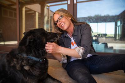 Julie Castle smiling and petting her dog Shadow