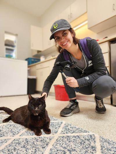 Katy Bentz petting a black at in Cat World