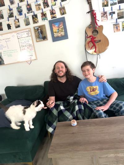 Kenobi the cat at home with her new family with one of them feeding her baby food on a spoon