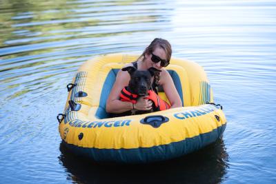 Person and dog in a yellow inflatable raft on the water