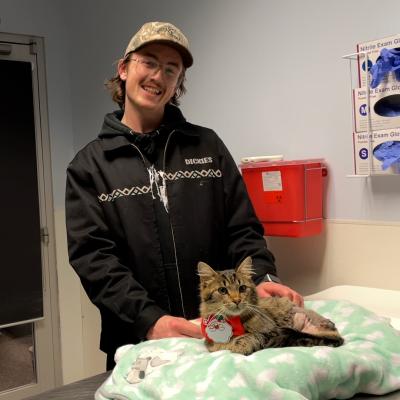 Matt with Lowe the cat on a blanket covered cat bed