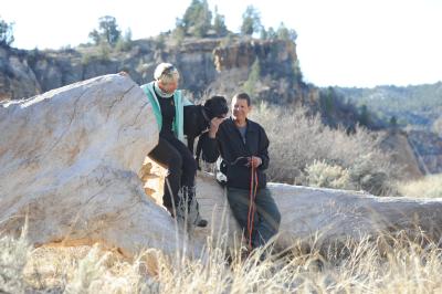 Mark and Kim Spragg outside on a rock with a large black dog