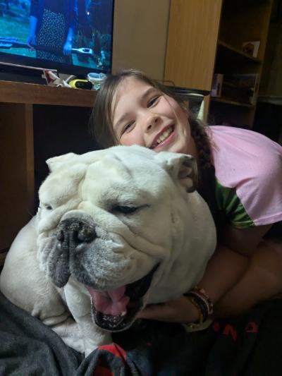 Wendy snuggling with Rush the English bulldog whose mouth is open