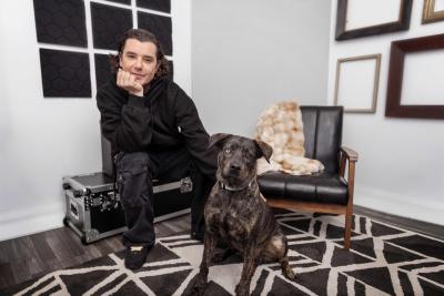 Gavin Rossdale sitting beside a brindle dog with odd-colored eyes