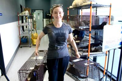 Kelly the volunteer holding two humane traps containing cats as part of trap-neuter-vaccinate-return