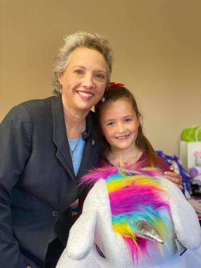 Madeline and an adult with a stuffed unicorn