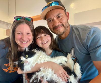 Venessa the cat being held by her new family