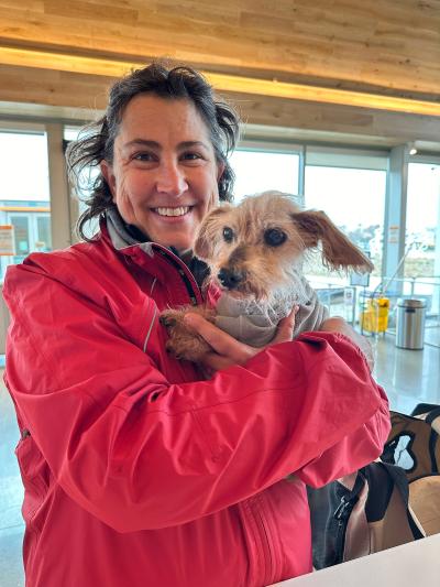 Smiling person holding Old Greg the dog