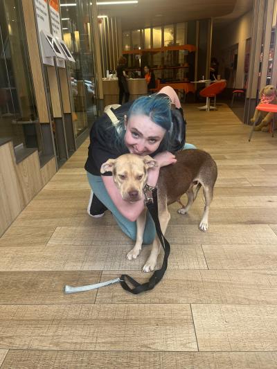 Adopter with blue hair hugging her new dog at the Best Friends Lifesaving Center in New York City