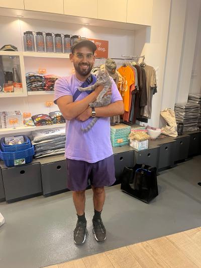 Smiling adopter holding a gray tabby at at the Best Friends Lifesaving Center in New York City
