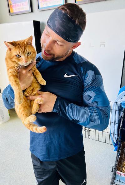 Catman Joe Perry holding an orange tabby cat