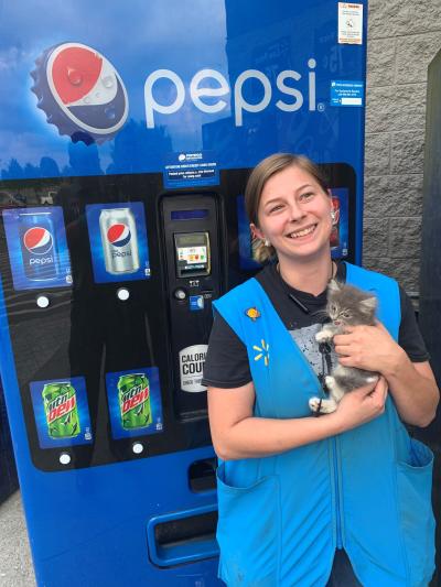 Lindsey Russell holding the rescued kitten in front of the Pepsi machine