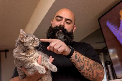 Chris Alton touching the nose of Jane the cat