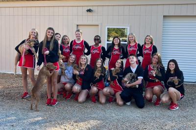 Cheerleading squad holding puppies