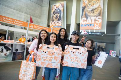 Group of people with two cardboard carriers carrying cats at the Best Friends Super Adoption in Utah