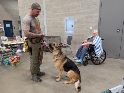 A person with Shadow the dog on a lead beside Donna in a wheelchair