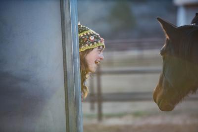 Shy DeLand playing hide-and-seek with Clint the horse