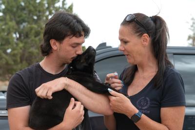Sweet Baby James the puppy with the people who adopted him, one of the people holding and kissing him