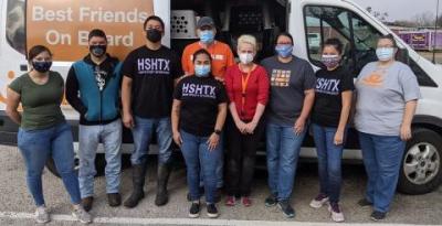 Nine people with masks standing in front of the side of open Best Friends transport van