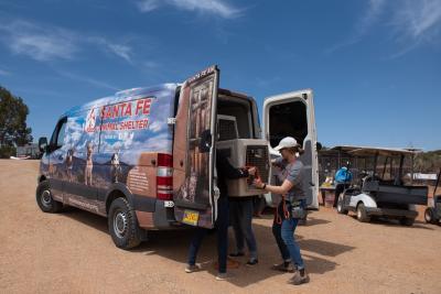 People taking a carrier out of a transport ven