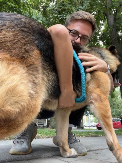 Volunteer Ben Richards hugging a German shepherd dog